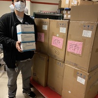 A man holding boxes of N95 masks. 