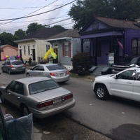 Image of cars driving by a house with balloons in front of it, for a pandemic style graduation party.