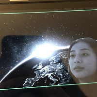 This is a picture of a girl's face superimposed over a background image of the earth from space. 