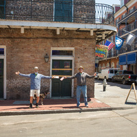 Two people spreading their arms out on the side of a street.