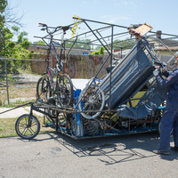 A person putting scrap in a metal cage.