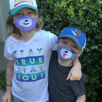 Photo of two children wearing masks. 