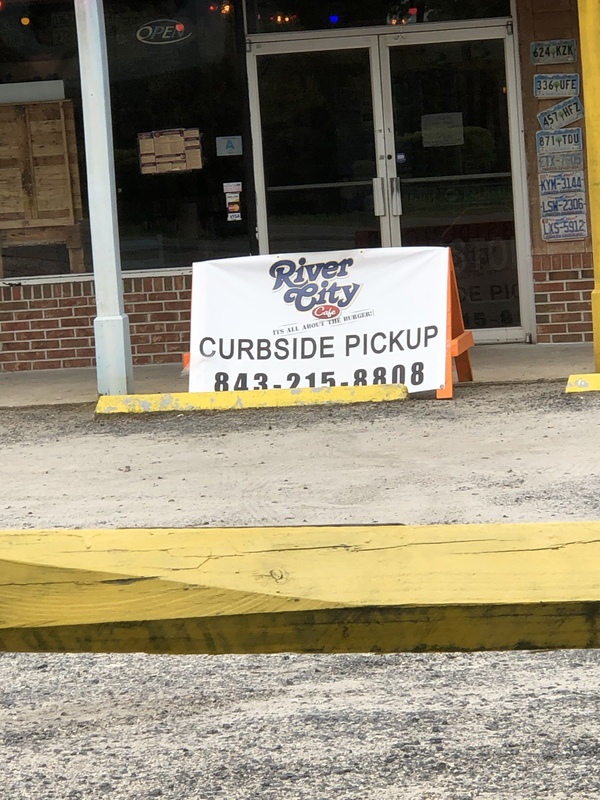 A sign in front of a restaurant says: "CURBSIDE PICKUP".