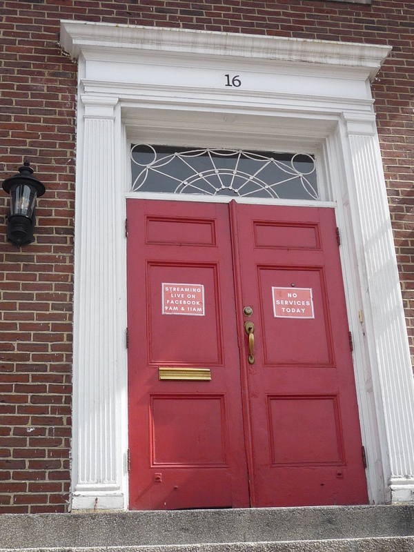 Double red doors with signs on them. 