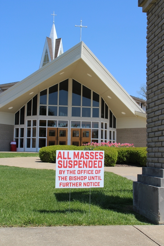 Church Yard Sign Reading "All Masses Suspended By The Office Of The Bishop Until Further Notice".