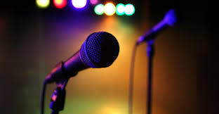 This is a picture taken of a pair of microphones sitting on a dimly lit stage. 