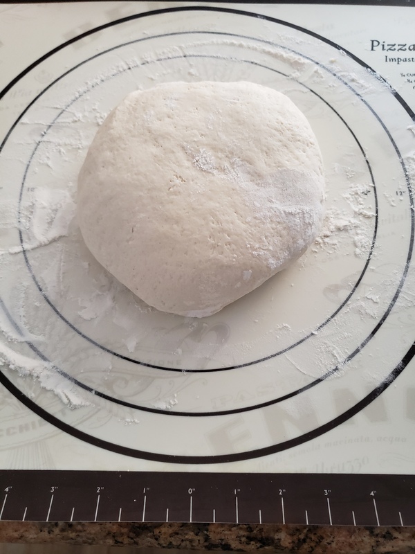 Photo of sourdough bread dough covered with flour. 
