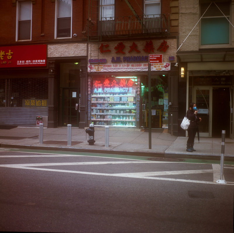 A picture of a pharmacy storefront taken from the street in Chinatown, New York City. 