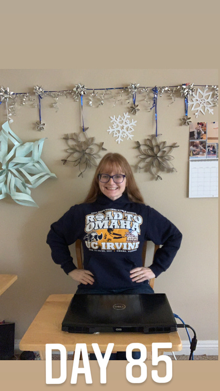 This is a picture of a girl wearing glasses and a UC Irvine sweatshirt standing with her hands on her hips in front of a closed laptop. There are paper snowflakes hanging on the wall in the background, and a caption at the bottom of the picture that reads "Day 85."