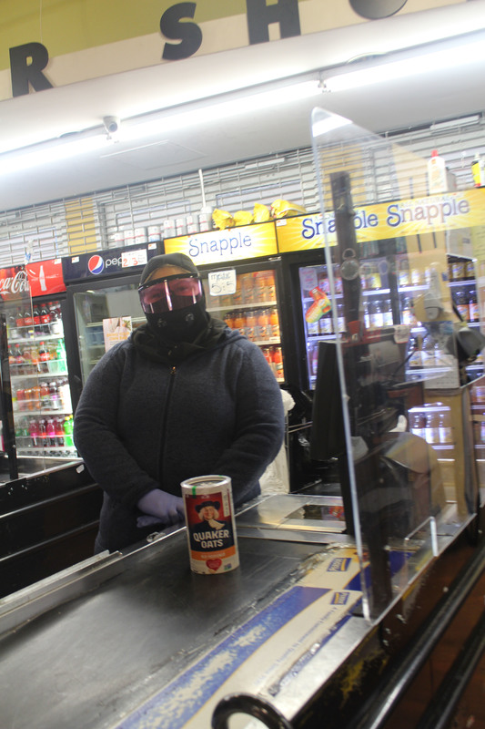 A cashier in a store with a mask on. 