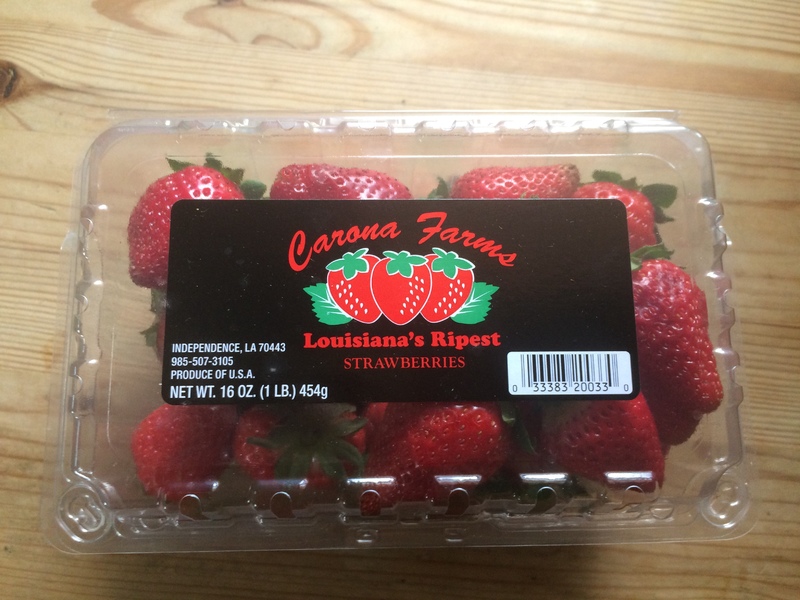 a plastic container of strawberries 