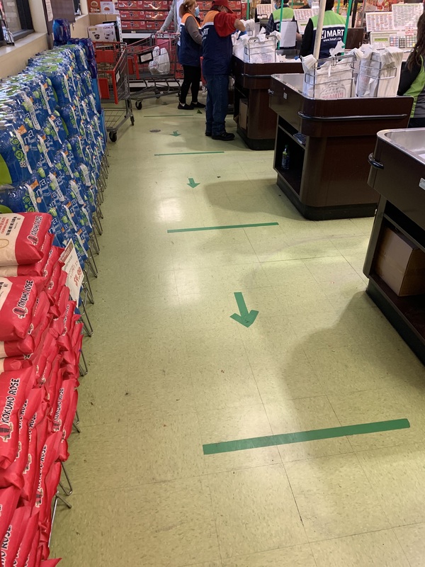 Social distancing markers on the floor of a grocery store. 