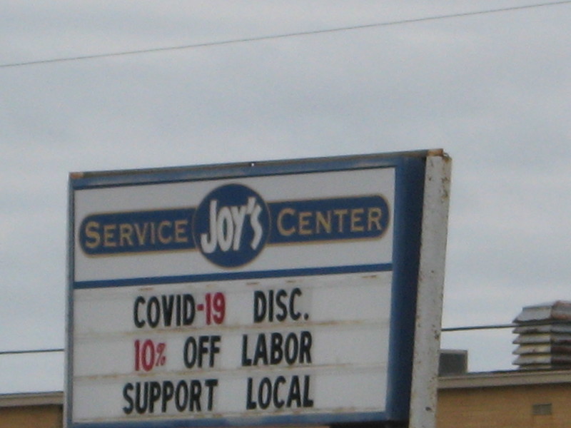 An auto mechanic's sign asking people to shop local