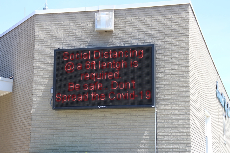 Digital Sign reading "Social Distancing at a 6 feet length is required. Be Safe. Don't spread COVID-19".