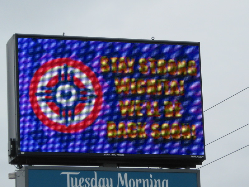 A billboard that reads "Stay strong Wichita! We'll be back soon!"