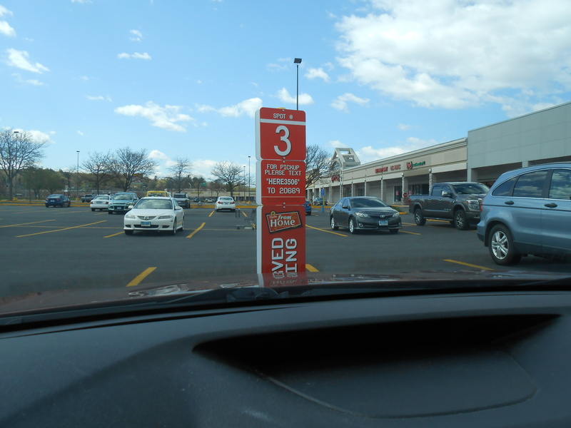 red pick up area sign for a store with a white number 3 on it