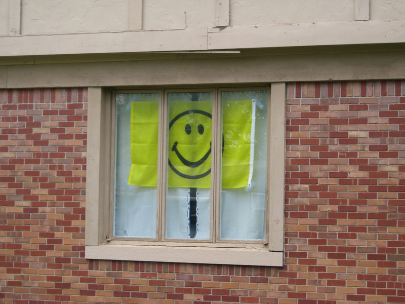 Image of a smiley face flag in a window.
