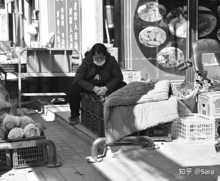 A photo of a woman in a store sitting and looking down.