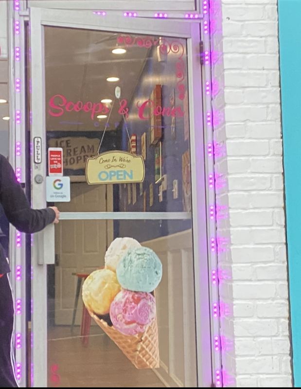 Photo of an ice cream store with a sign that reads, "open".