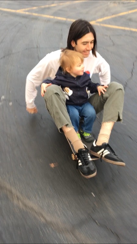 A man riding with a kid on a skateboard. 