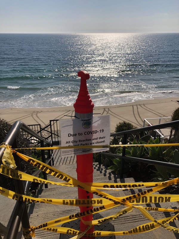 barrier blocking beach access and sign saying the beach is closed due to corona 