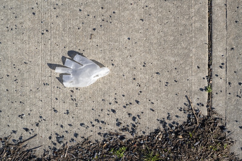 A latex glove laying on the sidewalk. 