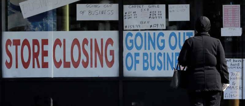 This is a picture of a series of signs that are posted in the front of a store window, and being read by a woman standing in front of them. The signs read: "Store Closing", "Going Out of Business", and "Carpet Sale". 
