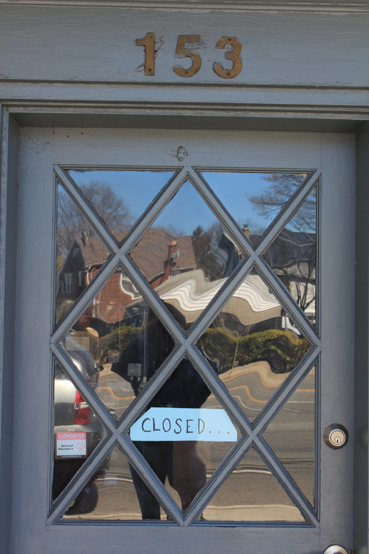 A business with a closed sign on the front door. 