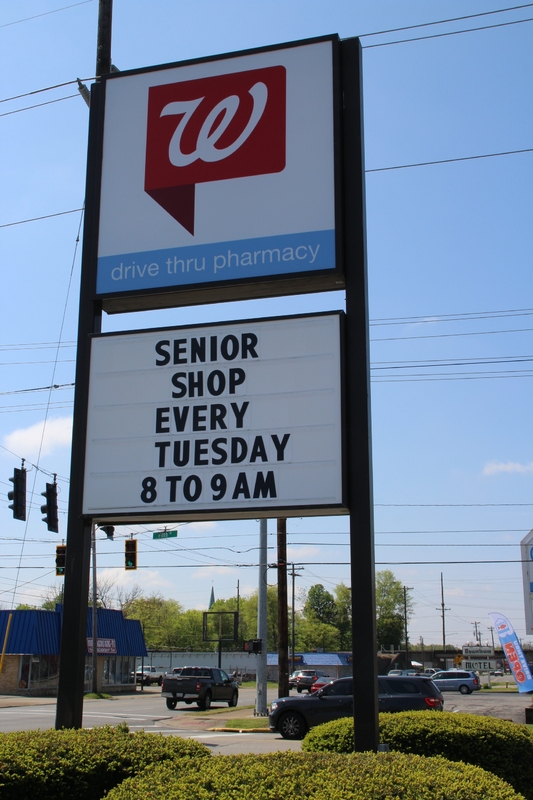 A sign outside a Walgreens reading "Senior Shop every Tuesday 8 to 9 AM".