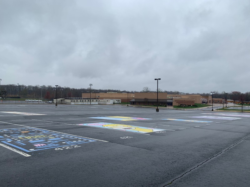 An empty parking lot with a building in the distance. 