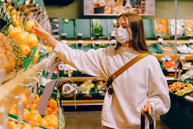 A woman wearing a mask in a grocery store.