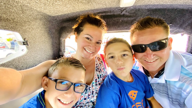 A family posing for a picture inside a car. 
