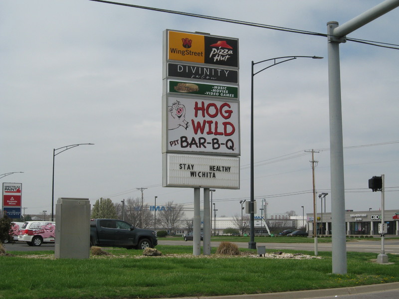 Image of business signs, the bottom one says stay healthy, Wichita. 