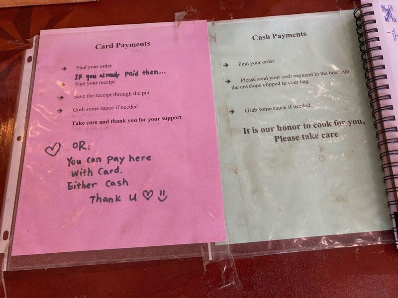 This is a picture taken of two slips of paper, each explaining how to purchase food with cash or card. 
