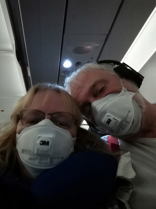 Two people with masks on a plane. 