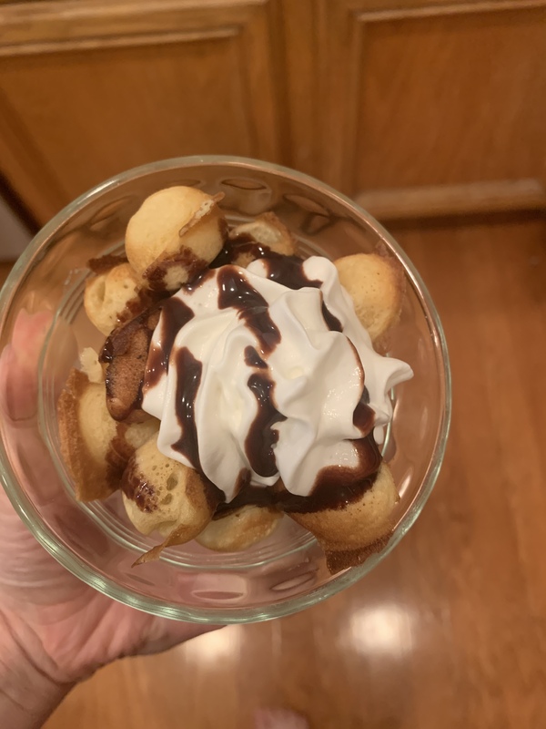 This is a picture of a completed Hong Kong Waffle, topped with chocolate sauce and whipped cream. 
