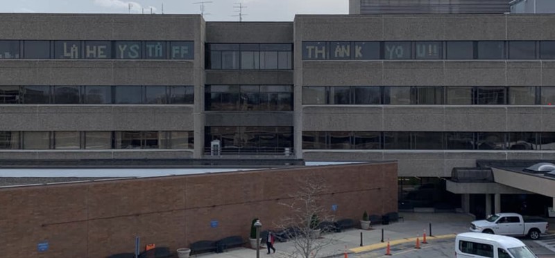  Lahey Hospital and Medical Center with 7 central unit on the top floor in the windows showing the message, "LAHEY STAFF THANK YOU!!"