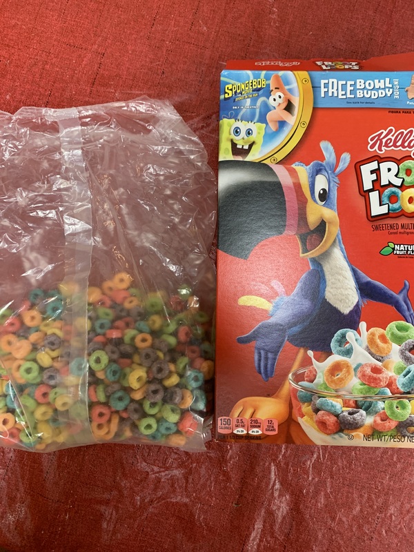 A red tablecloth with a half eaten Froot Loops bag (left side) and Froot Loops box (right side) on top. 