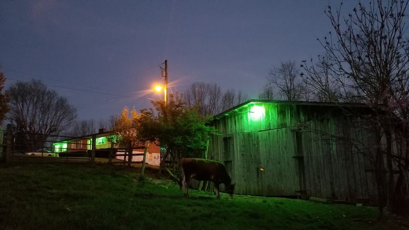 A barn with green lights. 