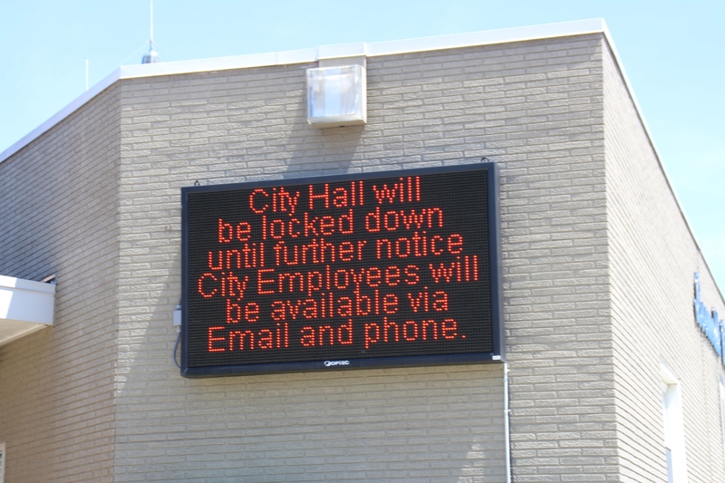 Digital sign reading "City hall will be locked down until further notice. City employees will be available via Email and Phone".