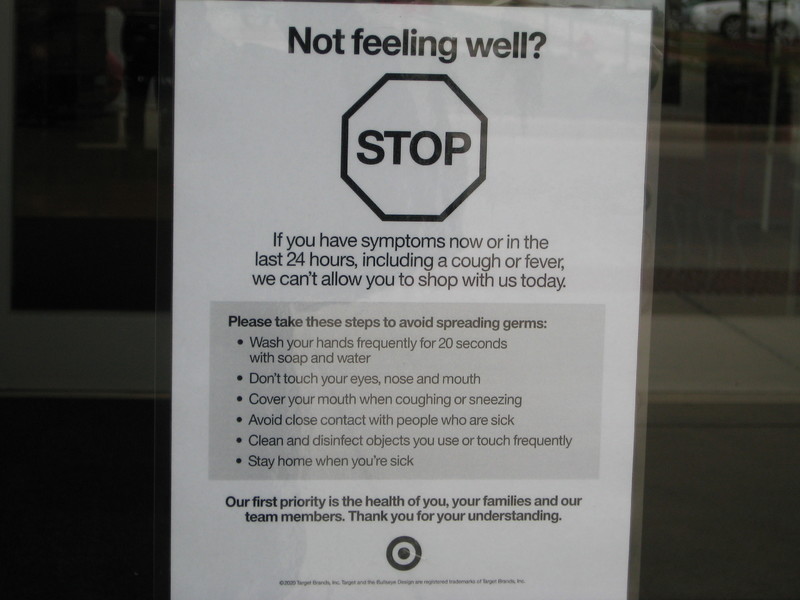 Image outside of a Target store which says not feeling well? Stop. If you have symptoms now or in the last 24 hours, including a cough or fever, we can't allow you to shop with us today. Please take these steps to avoid spreading germs: wash your hands frequently for 20 seconds with soap and water, don't touch your eyes, nose and mouth, cover your mouth when coughing or sneezing, avoid close contact with people who are sick, clean and disinfect objects you use or touch frequently, stay home when you're sick. Our first priority is the health of you, your families and our team members. Thank you for your understanding.