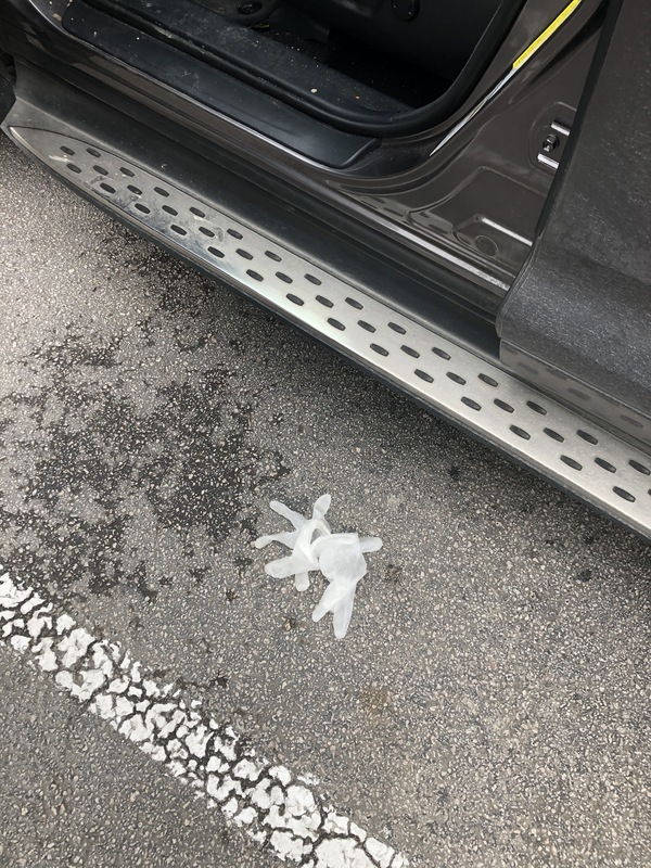 A disposable glove is on the ground in a parking lot. 
