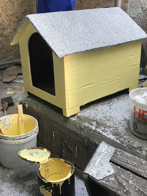 A yellow painted dog house.