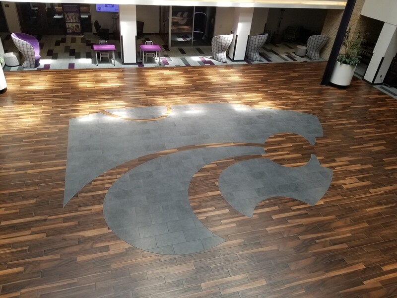 This is a picture taken of a logo inlaid into a wooden floor. 