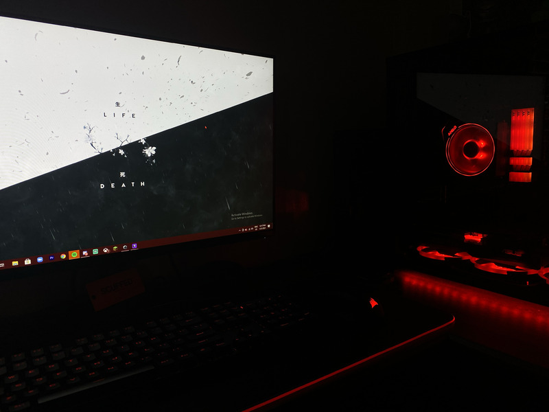 A picture taken of a PC in the dark, which is covered in red LED lights. 