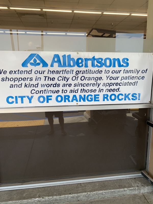 Image of a banner outside of a grocery store which reads Albertsons, we extend our heartfelt gratitude to our family of shoppers in the city of Orange. Your patience and kind words are sincerely appreciated! Continue to aid those in need. City of Orange Rocks!