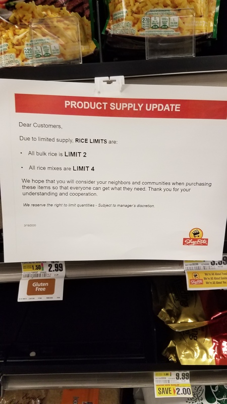 A sign at a grocery store gives a status supply update on rice and the amount of rice someone could buy. 