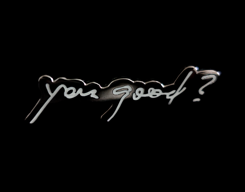 This is a picture of a graphic which depicts the words "You good?" in cursive against a black background. 