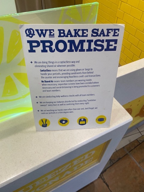 This is a picture of a sign at a Wetzel's Pretzels restaurant which guarantees that food has been made without employees making skin contact with the food. 