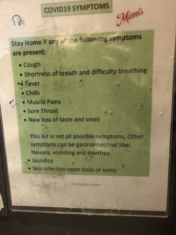 A poster listing the symptoms of COVID-19.